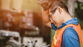worker wiping the sweat off his brow