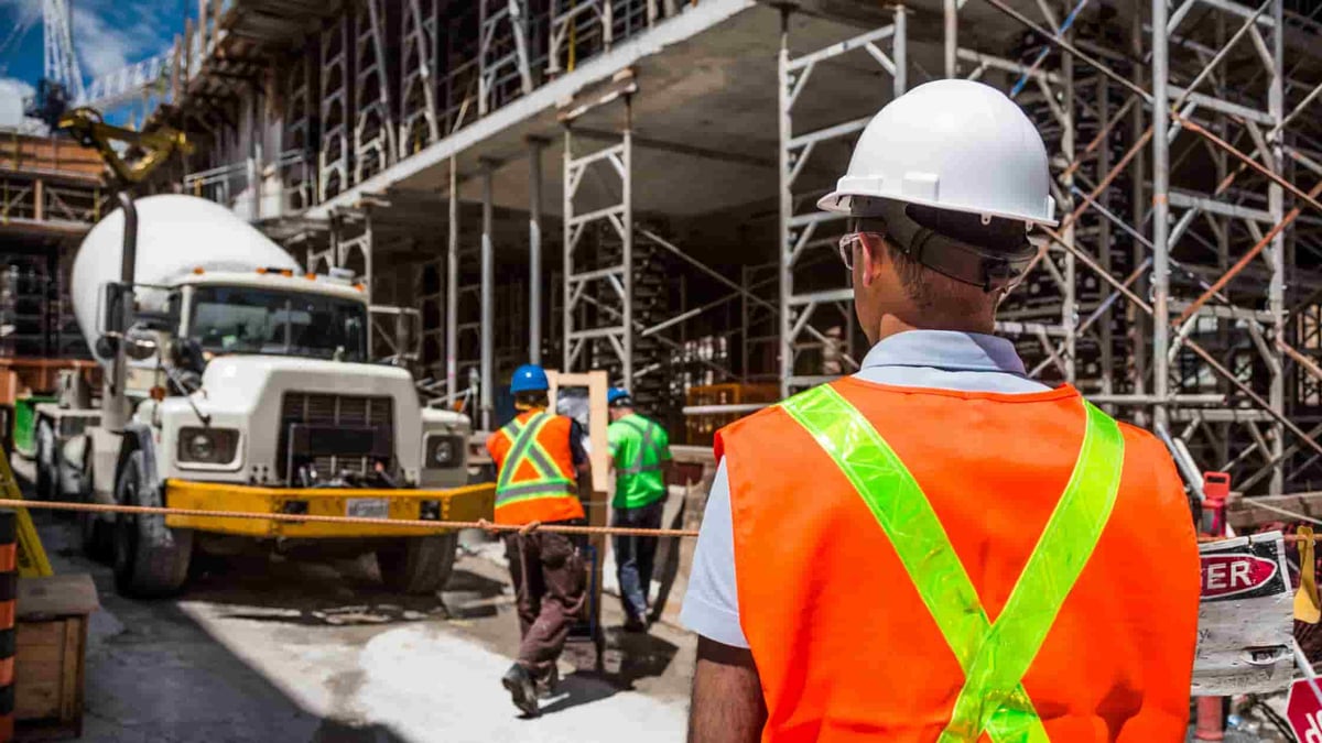 employees working on a construction site man standing outside of construction zone