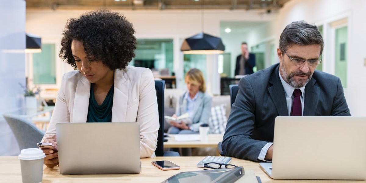 man and woman on laptops - training needs for a multigenerational workforce - september 2018