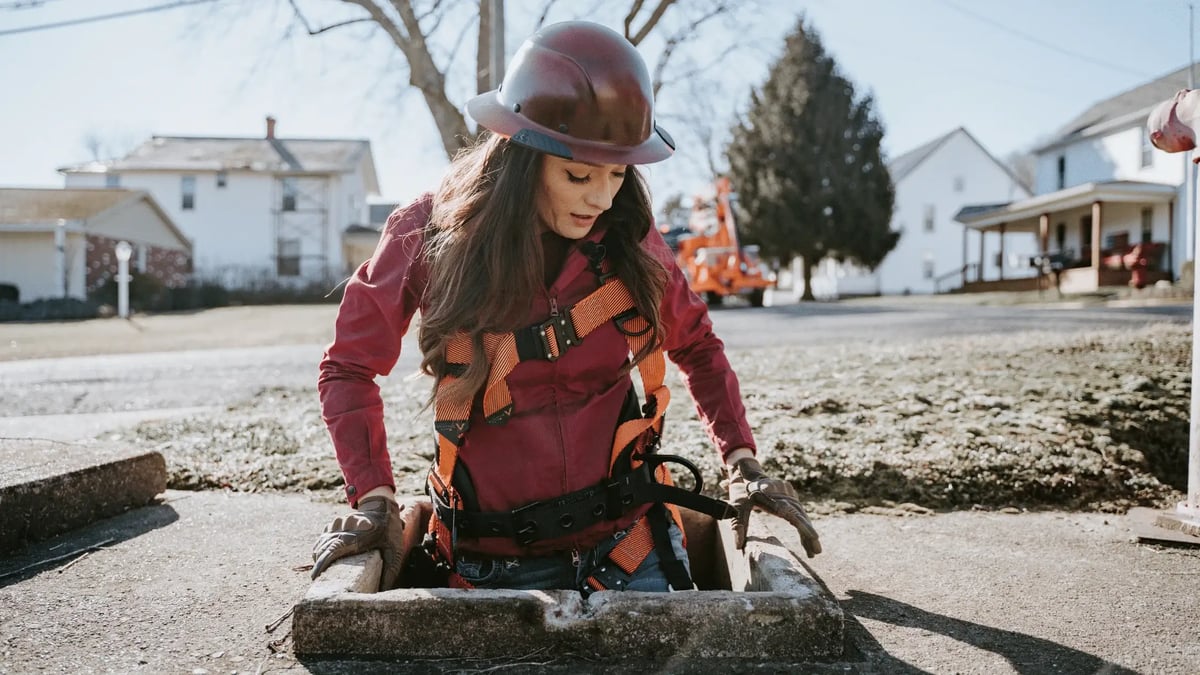 woman crawling in man hole