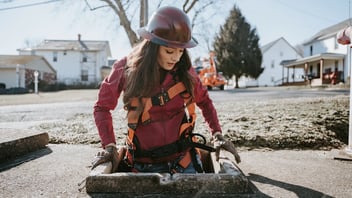 woman crawling in man hole 