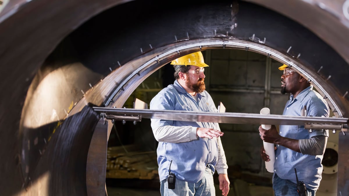 two employees talking about a metal project
