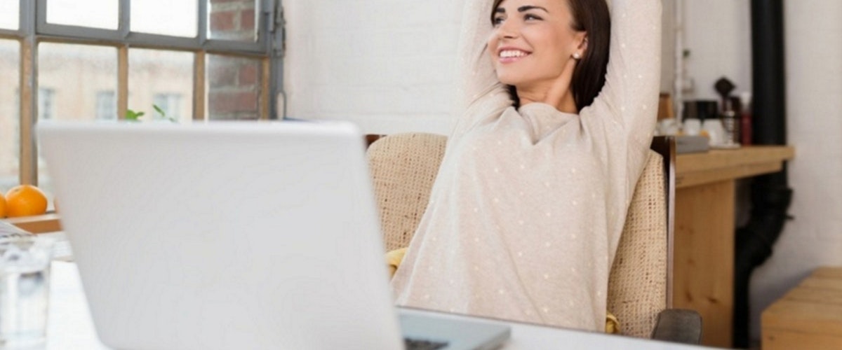 woman working at a computer and happy - blog image