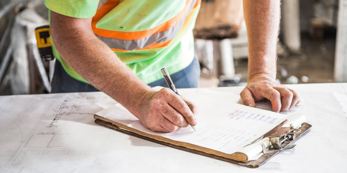 construction man writing clipboard - qualities of a good leader - august 2018